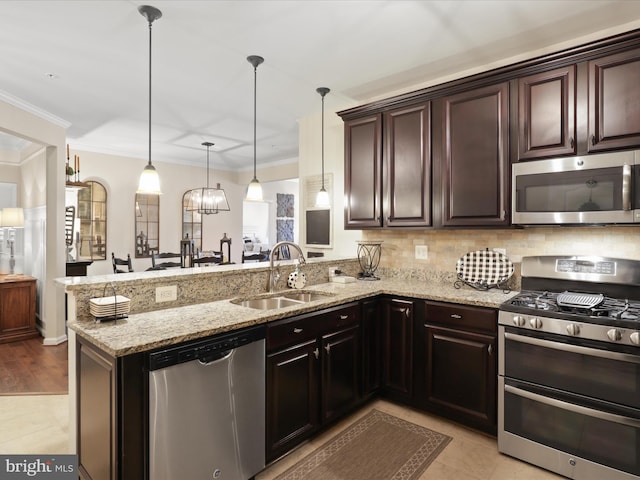 kitchen featuring dark brown cabinetry, appliances with stainless steel finishes, a peninsula, pendant lighting, and a sink