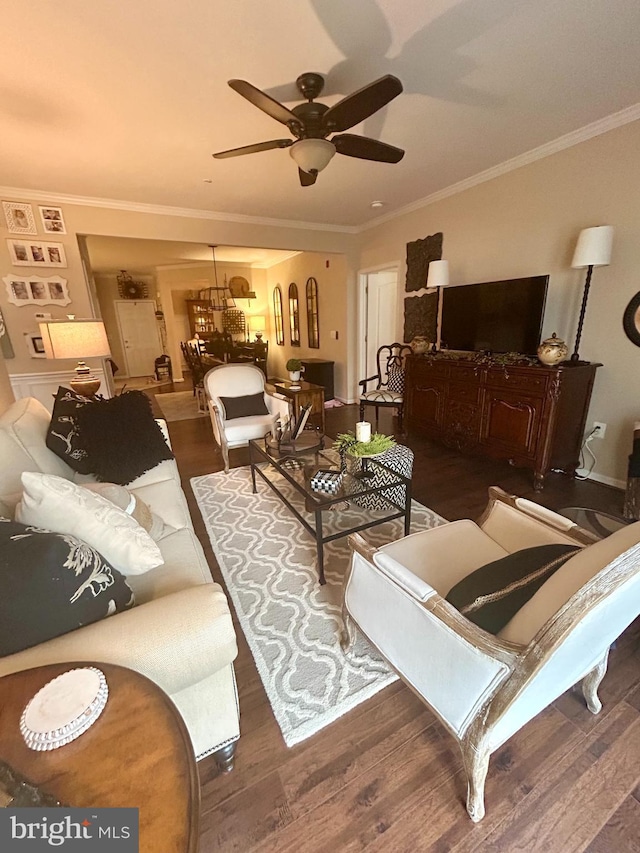 living area featuring a ceiling fan, ornamental molding, and wood finished floors