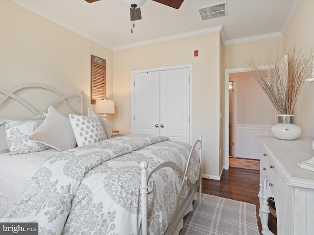 bedroom featuring dark wood-type flooring, a closet, visible vents, and crown molding