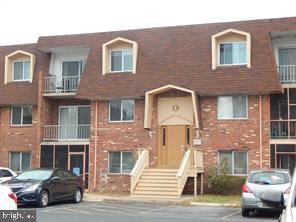 view of front of home with uncovered parking and brick siding