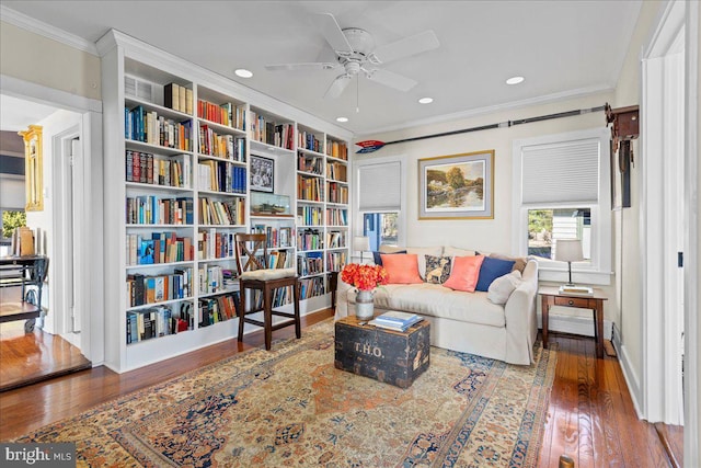 sitting room with a ceiling fan, dark wood finished floors, crown molding, and baseboards