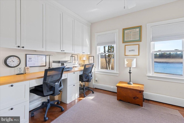 office featuring baseboards, built in desk, a baseboard radiator, and light wood-style floors