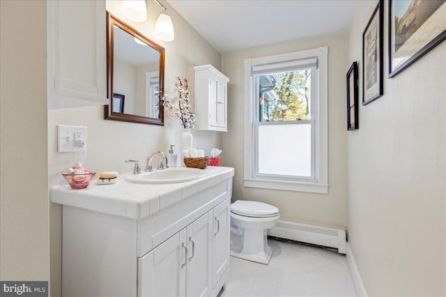 bathroom featuring toilet, a baseboard heating unit, vanity, tile patterned flooring, and baseboards