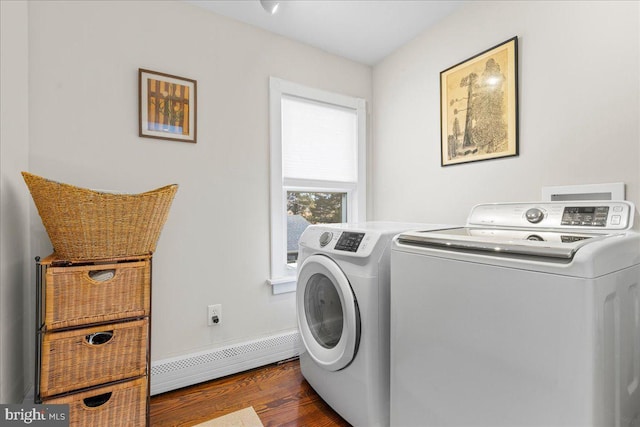 clothes washing area featuring a baseboard heating unit, laundry area, separate washer and dryer, and dark wood finished floors