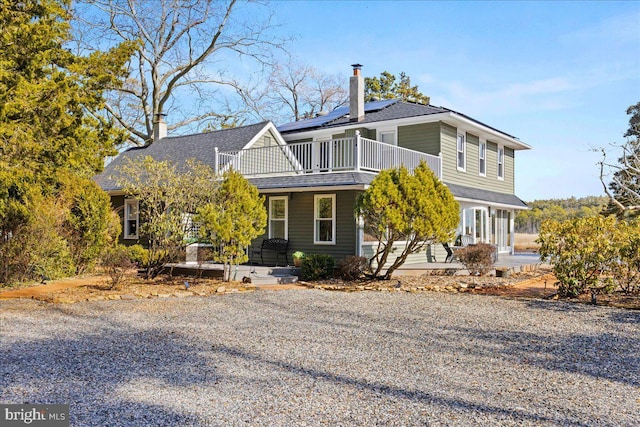 view of front of house with a chimney and solar panels