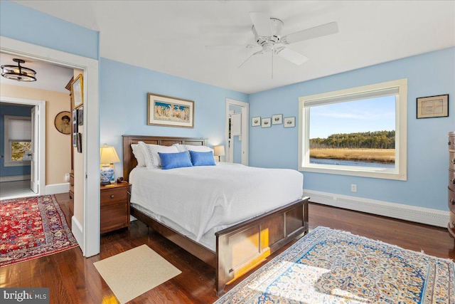 bedroom featuring a ceiling fan, a baseboard radiator, baseboards, and dark wood-style flooring