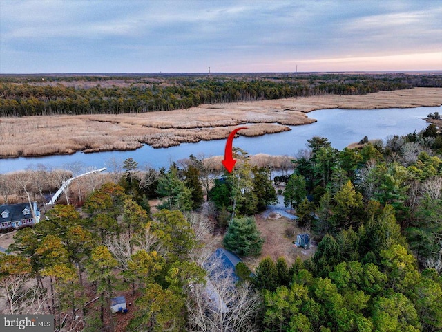 aerial view at dusk featuring a water view