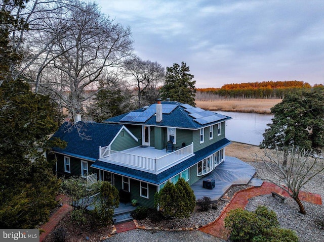 view of front of property with a balcony and solar panels