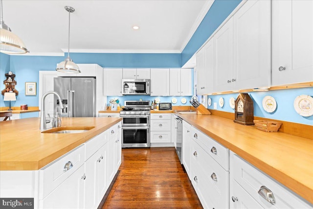 kitchen featuring hanging light fixtures, appliances with stainless steel finishes, light countertops, and white cabinets