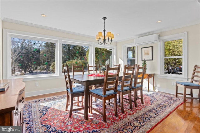 dining space featuring plenty of natural light, ornamental molding, a notable chandelier, and a wall mounted AC