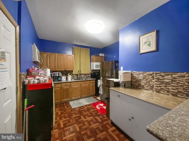 kitchen with white microwave, tasteful backsplash, brown cabinetry, and a sink