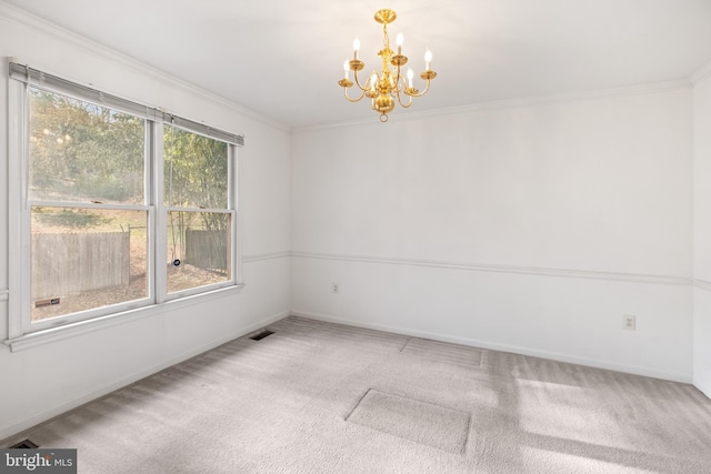 carpeted spare room with baseboards, visible vents, ornamental molding, and a chandelier