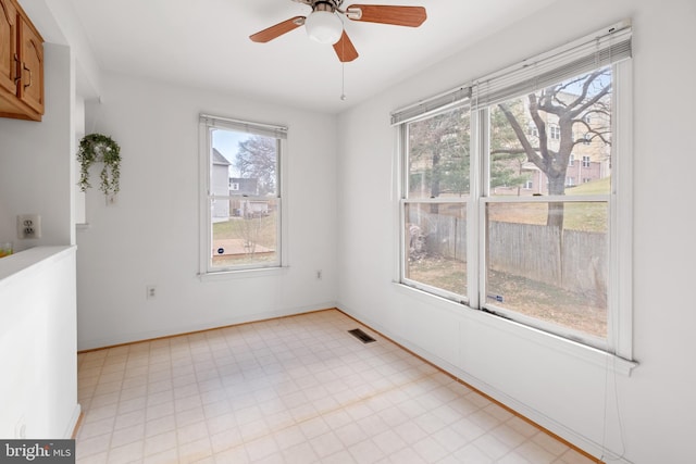 unfurnished room featuring a ceiling fan, visible vents, baseboards, and light floors