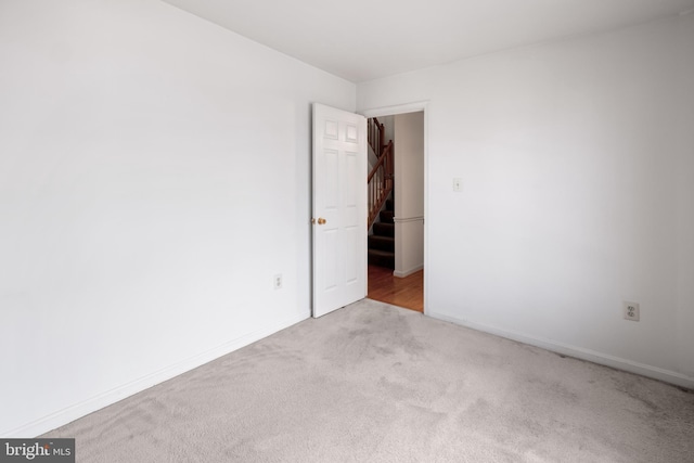 spare room featuring carpet and baseboards