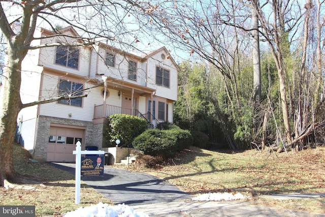 view of front of property featuring brick siding, driveway, and an attached garage