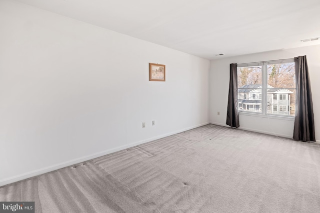 empty room featuring carpet floors, visible vents, and baseboards