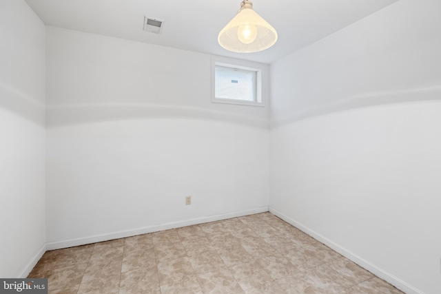 basement with baseboards and visible vents