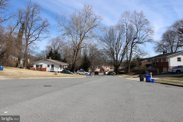 view of street with a residential view, curbs, and sidewalks