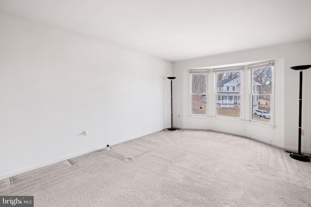 carpeted empty room featuring baseboards