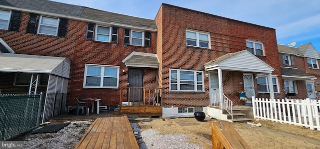 view of property featuring fence and brick siding