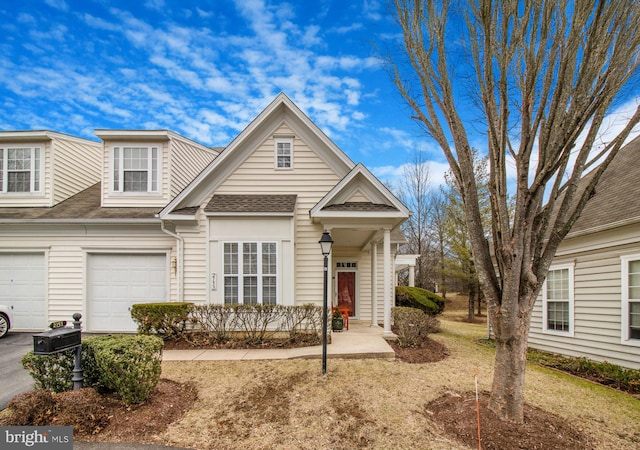 multi unit property featuring driveway, an attached garage, and a shingled roof