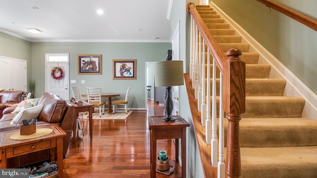 staircase featuring baseboards, ornamental molding, wood finished floors, and recessed lighting