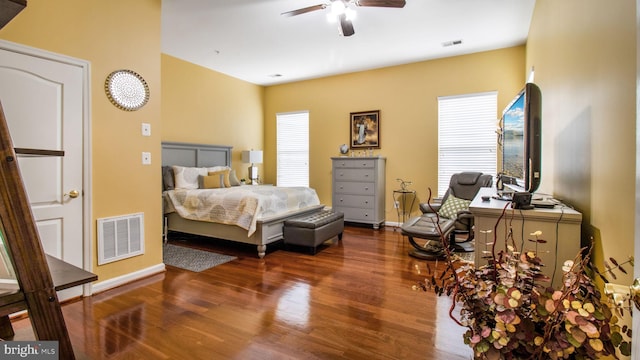 bedroom with dark wood-style floors, a ceiling fan, visible vents, and baseboards