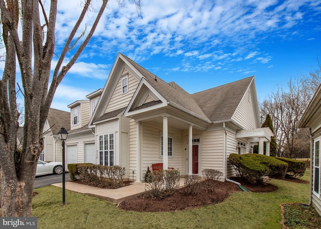 view of front of property with aphalt driveway, a front yard, a shingled roof, and a garage