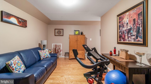 workout room with light wood-style floors and baseboards