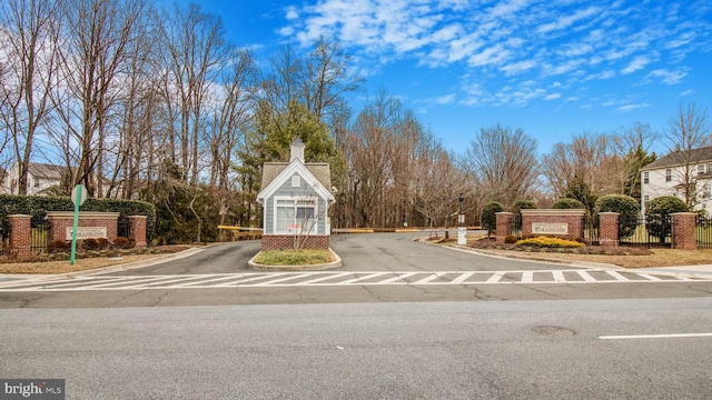 view of street featuring traffic signs, curbs, and a gated entry