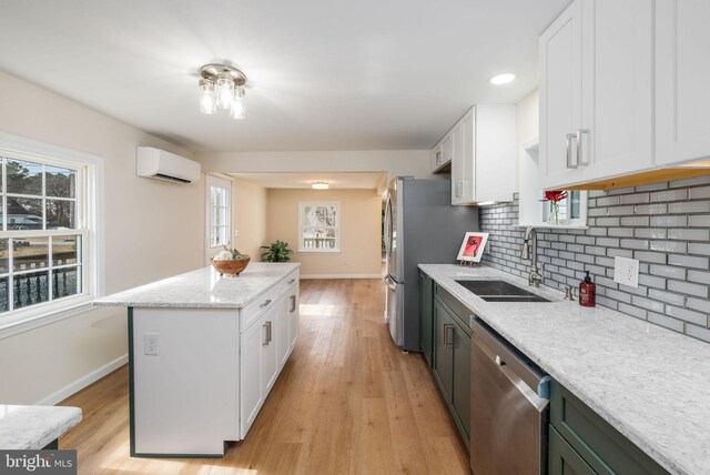 kitchen featuring appliances with stainless steel finishes, white cabinets, and a sink