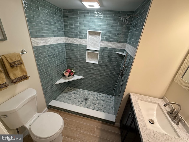 full bath with a stall shower, vanity, and toilet