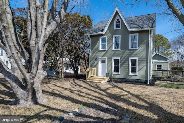 view of front of property with a front yard and roof with shingles