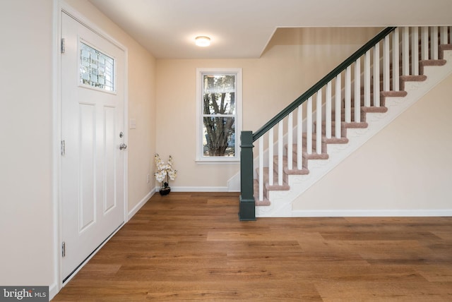 entrance foyer with stairs, baseboards, and wood finished floors