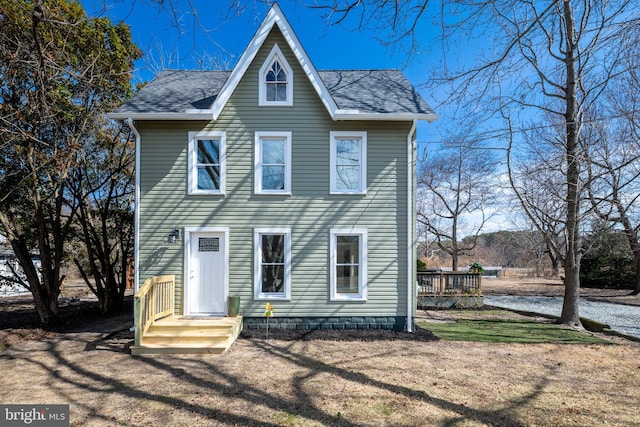 view of front of property featuring a front lawn and roof with shingles