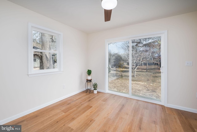 unfurnished dining area with light wood-type flooring, plenty of natural light, and baseboards