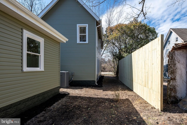 view of home's exterior featuring central AC unit and fence