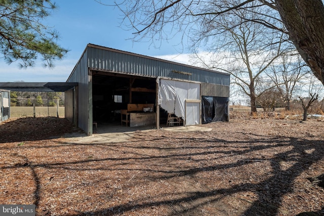 view of pole building with dirt driveway