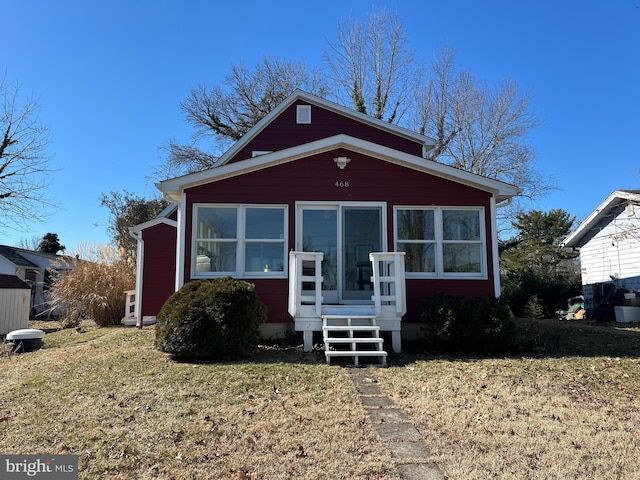 bungalow-style home with a sunroom and a front lawn