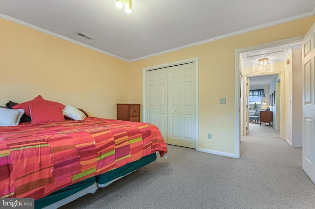 carpeted bedroom featuring ornamental molding, a closet, visible vents, and baseboards