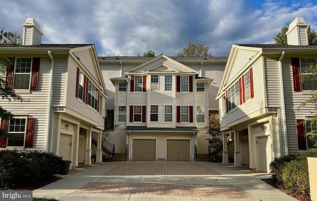 townhome / multi-family property featuring a garage and decorative driveway