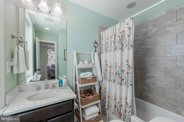 bathroom featuring toilet, shower / bath combo, connected bathroom, and vanity