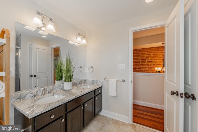 bathroom with double vanity, tile patterned flooring, baseboards, and a sink