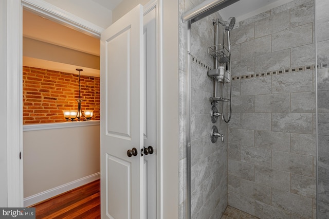 bathroom with a shower stall, baseboards, and wood finished floors