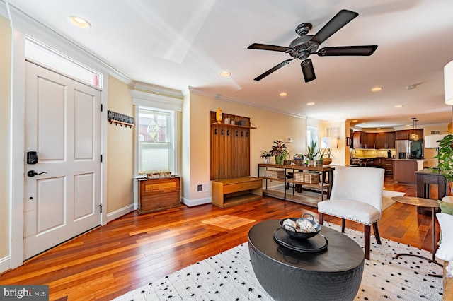 living area with baseboards, light wood finished floors, recessed lighting, and crown molding