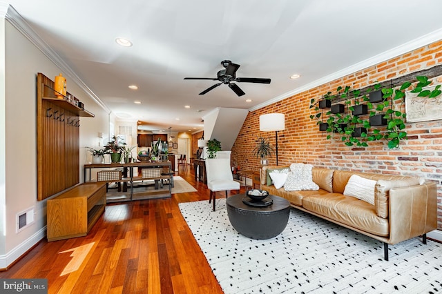 living room featuring brick wall, hardwood / wood-style floors, and crown molding