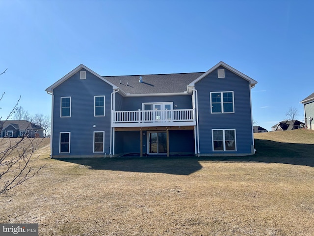 rear view of property featuring a yard and a wooden deck