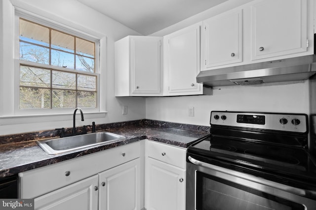 kitchen with under cabinet range hood, a sink, white cabinets, electric stove, and dark countertops