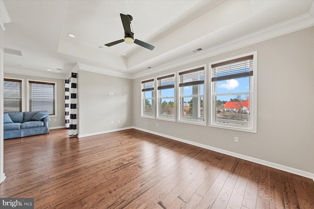 unfurnished living room featuring a raised ceiling, visible vents, baseboards, and hardwood / wood-style flooring