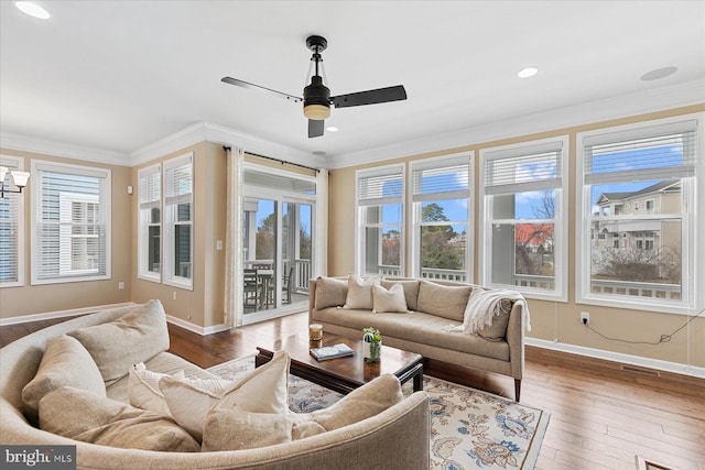 living room featuring dark wood-style floors, a healthy amount of sunlight, and crown molding